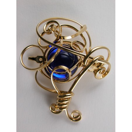 Broche fantaisie dorée, finition artisanale avec une pierre de couleur bleu saphir.