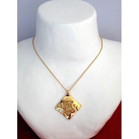 Pendentif doré fait main par un artisan d'art.