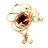 Broche dorée avec une pierre rouge, bijou d'art.