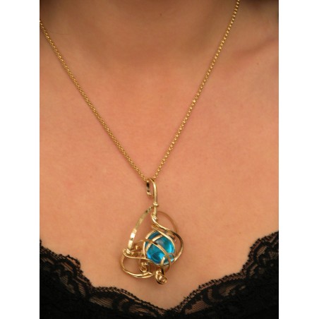 Bijou artisanal, pendentif doré sur chaîne longue.