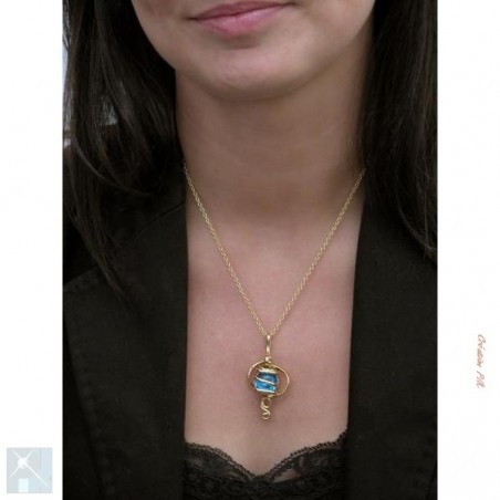 Pendentif artisanal doré avec une pierre bleue claire.